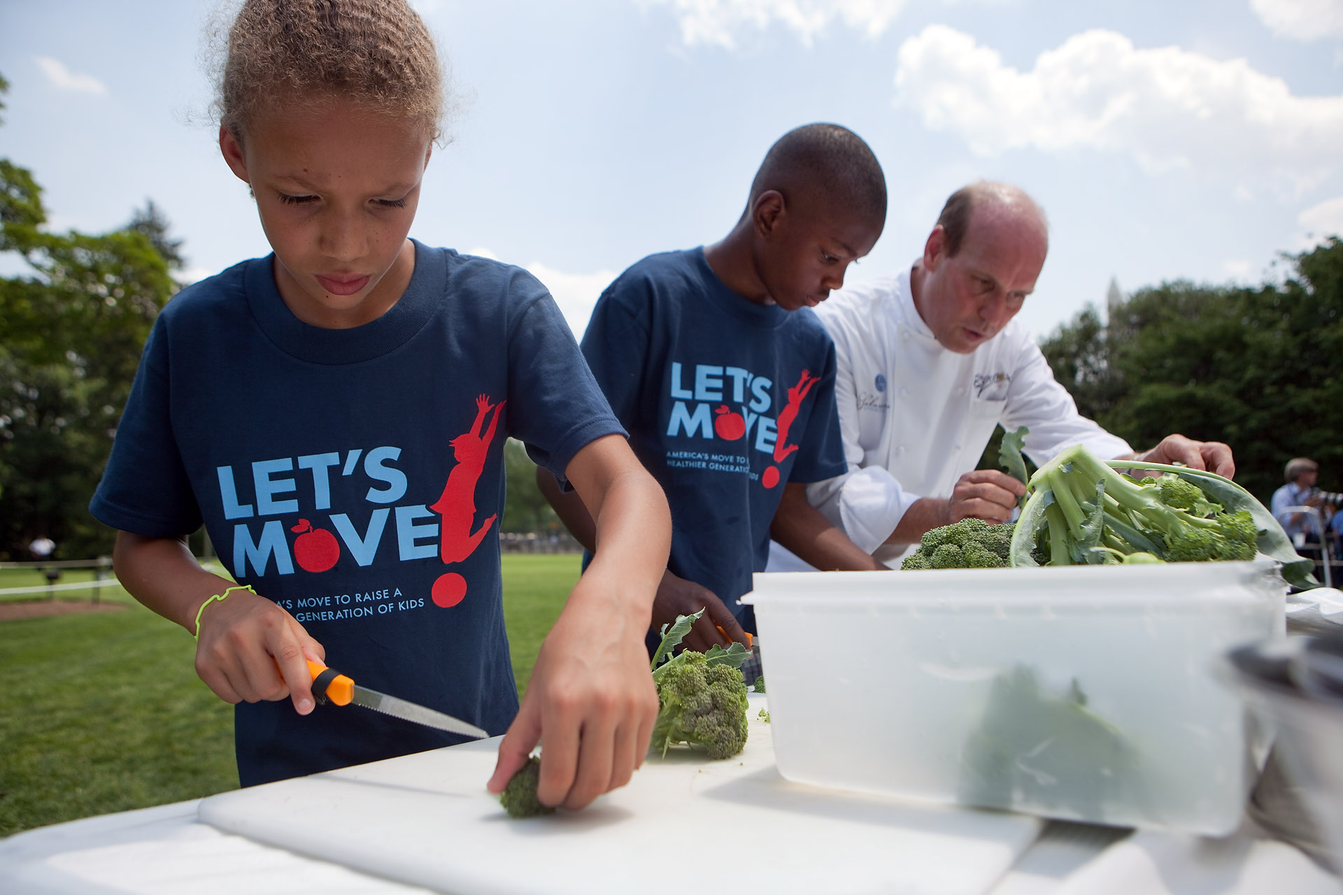 School children trim broccoli 