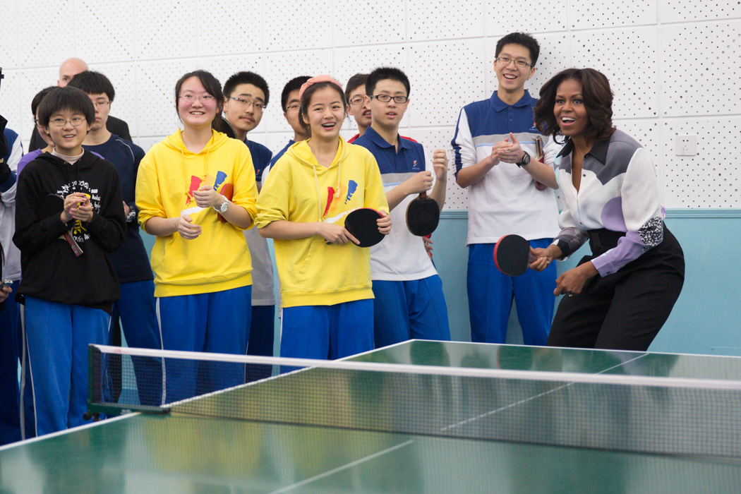 First Lady Michelle Obama plays ping pong with students while touring the Beijing Normal School in Beijing, China