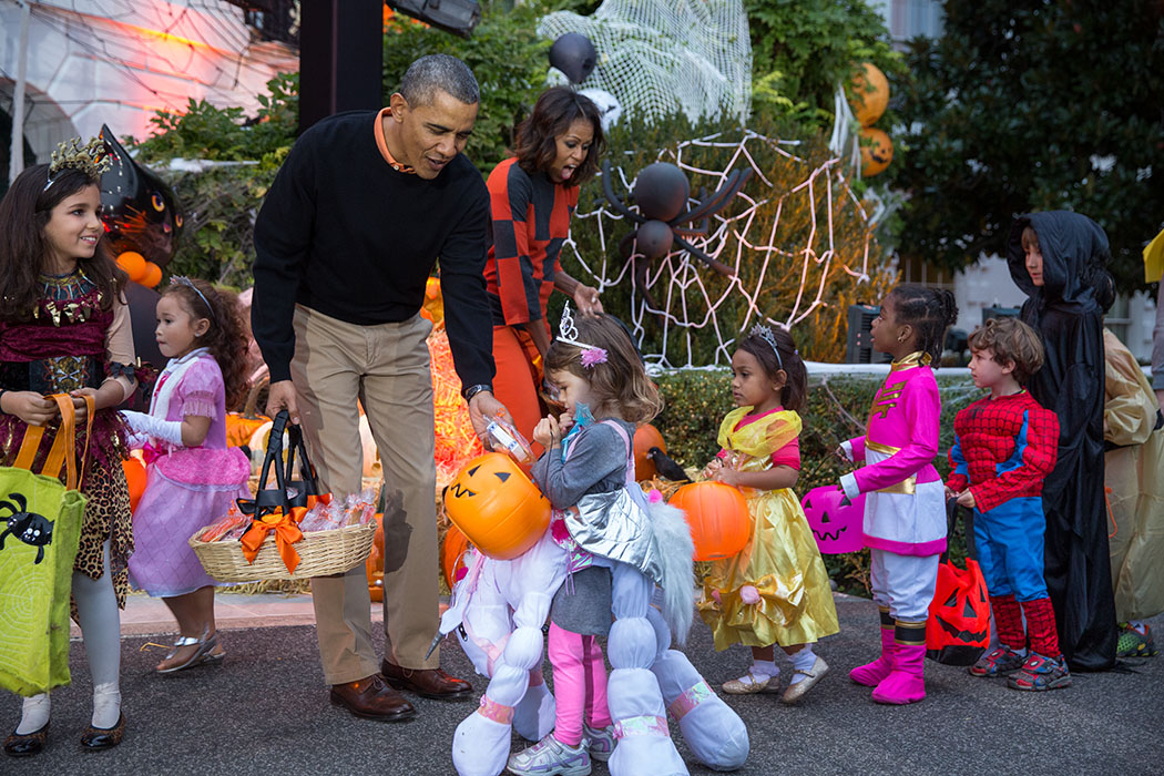 President Barack Obama and First Lady Michelle Obama hand out Halloween treats to local children