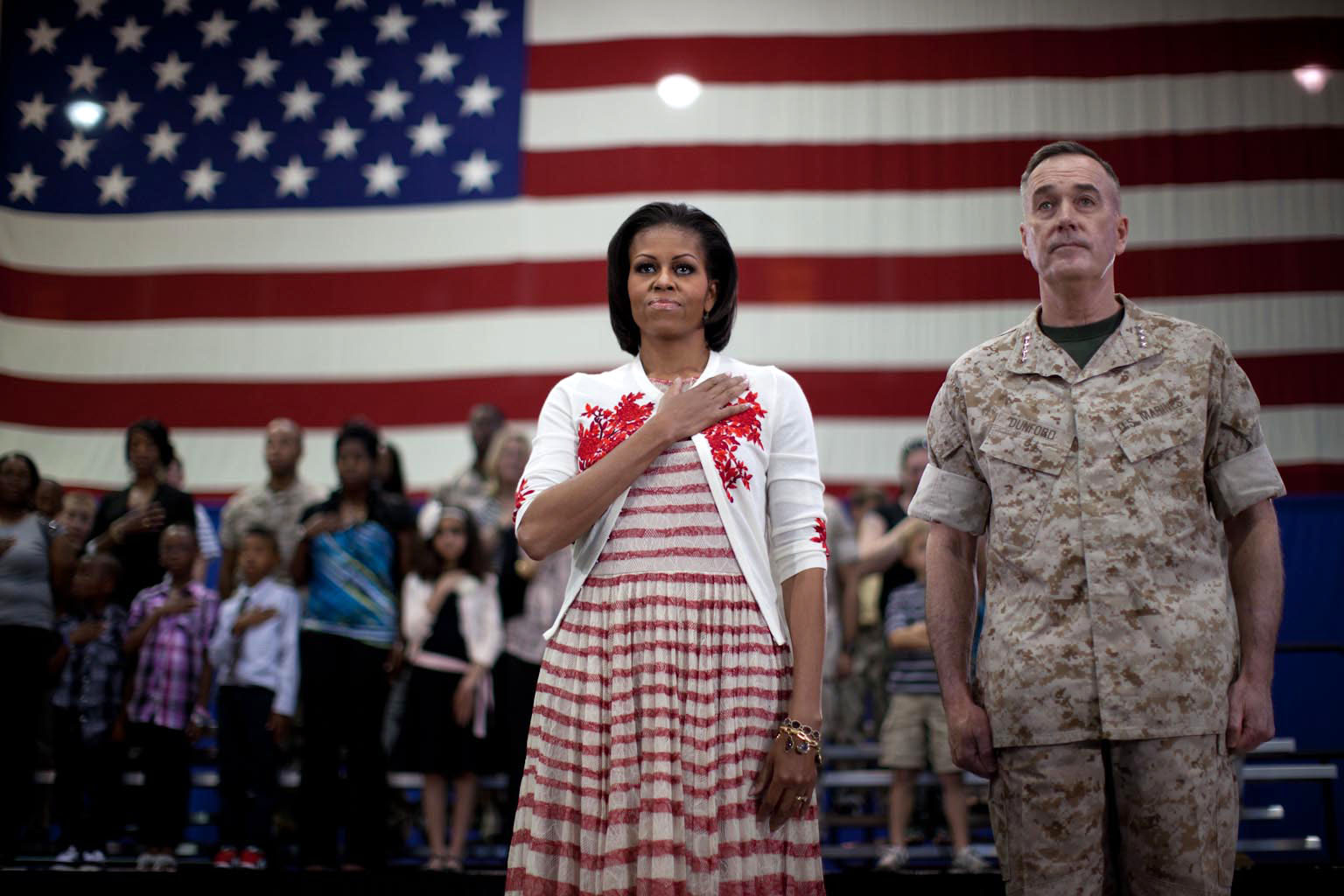 First Lady Michelle Obama and Gen. Joseph Dunford stand during national anthem at Goettge Memorial Field House at Camp Lejeune, N.C.