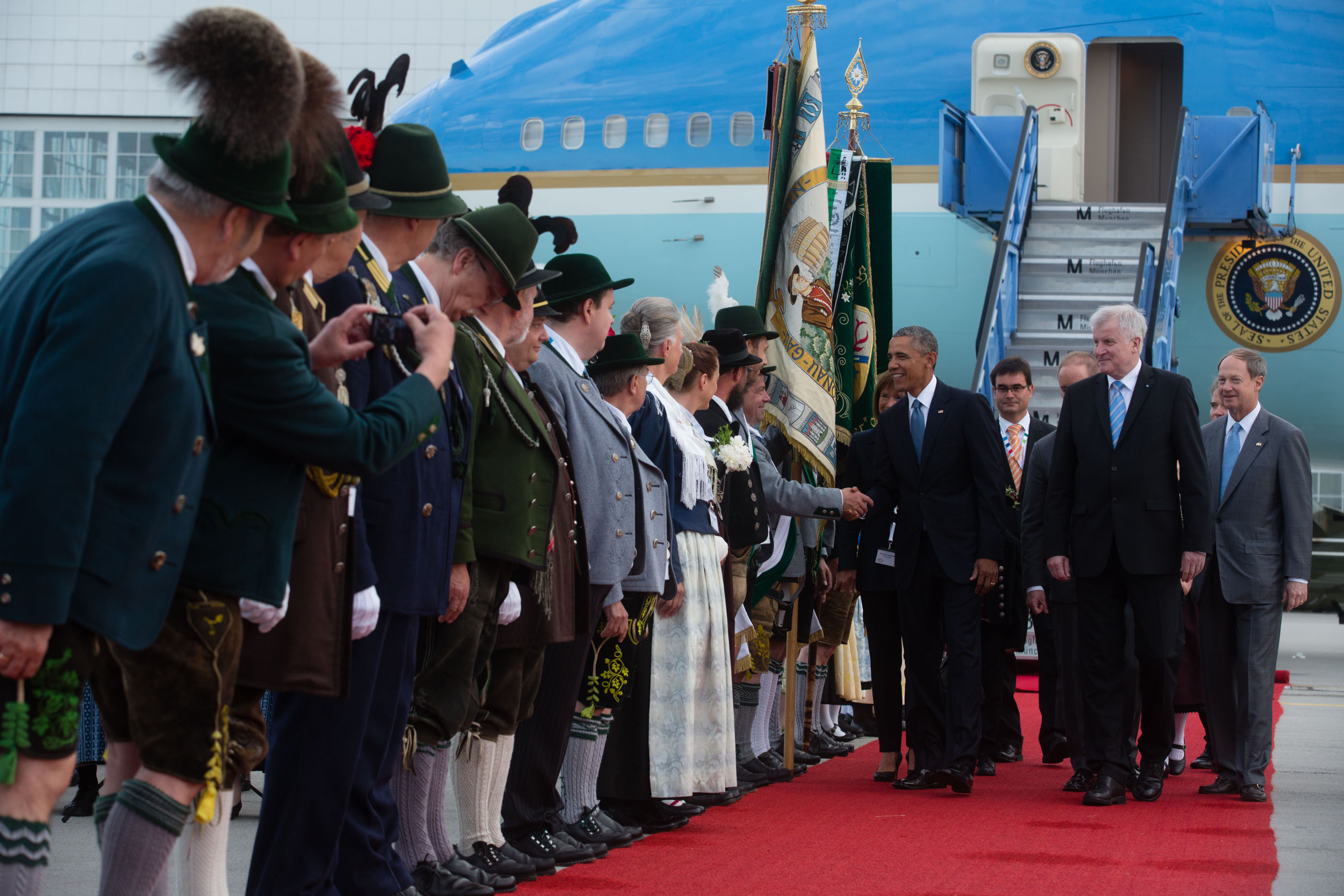 President Obama is greeted by folks in traditional Bavarian dress