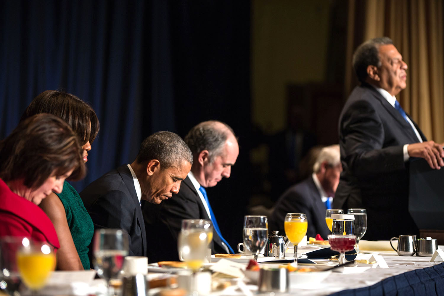 The President and First Lady Michelle Obama join former Atlanta Mayor Andrew Young in the closing prayer during the National Prayer Breakfast