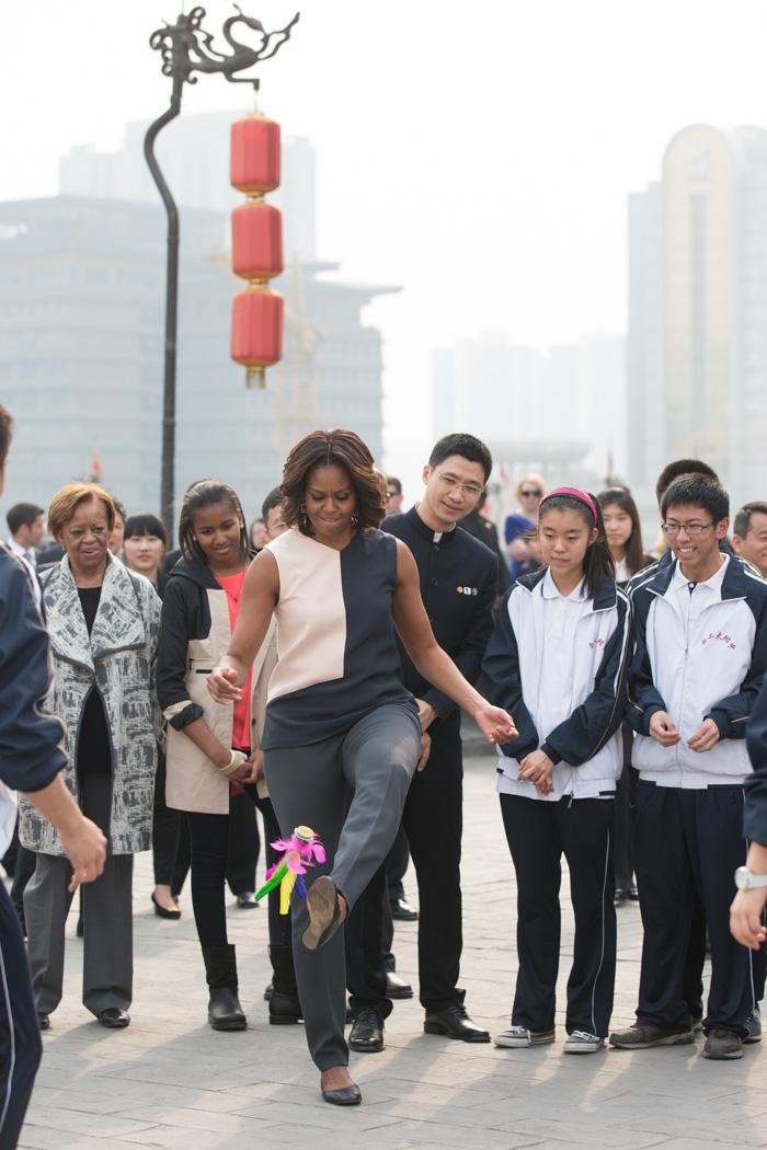 First Lady Michelle Obama participates in a hacky sack demonstration with the help of student instruction during her visit to the Xi'an City Wall with Sasha, Malia and Marian Robinson in Xi'an, China