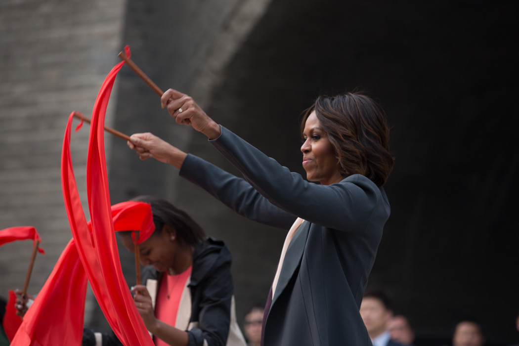 First Lady Michelle Obama waves a ribbon with Sasha and Malia as they watch a performance during their visit to the Xi'an City Wall in Xi'an, China