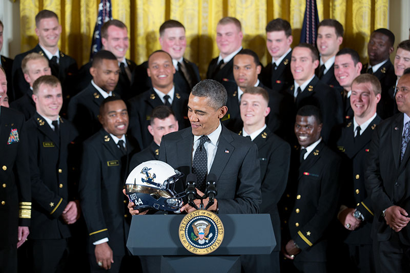 President Barack Obama examines the helmet given to him by the United States Naval Academy, who won the Commander-in-Chief Trophy, April 12, 2013