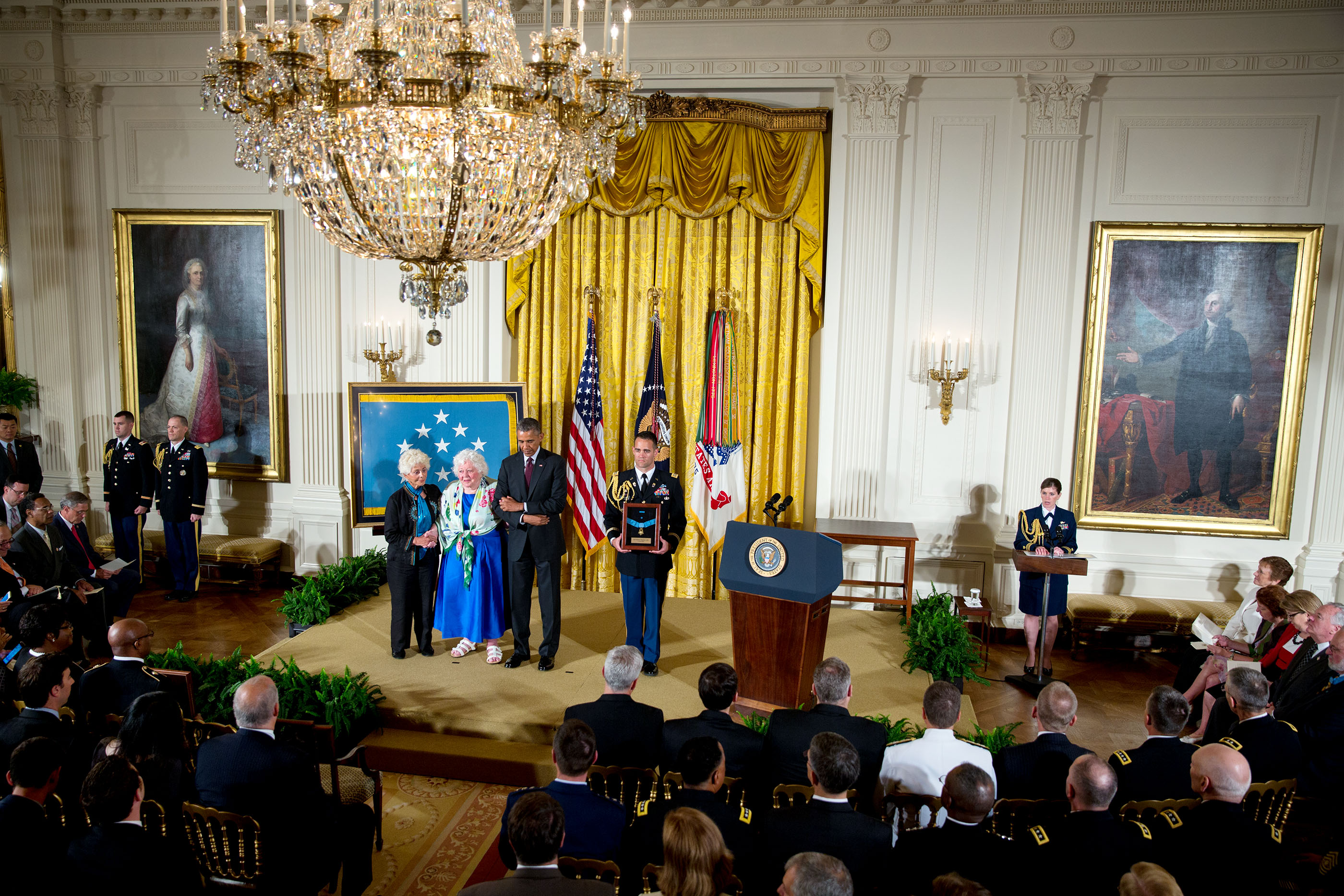 President Barack Obama stands with Ina Judith Bass (left) and Elise Shemin-Roth as the citation is read awarding the Medal of Honor posthumously to their father, Army Sergeant William Shemin, for conspicuous gallantry during World War I, at a ceremony in 