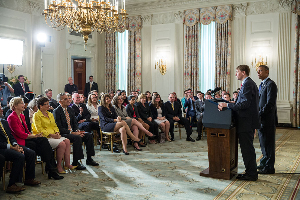 President Barack Obama listens to Richard Cordray deliver remarks following his confirmation as Director of the Consumer Financial Protection Bureau