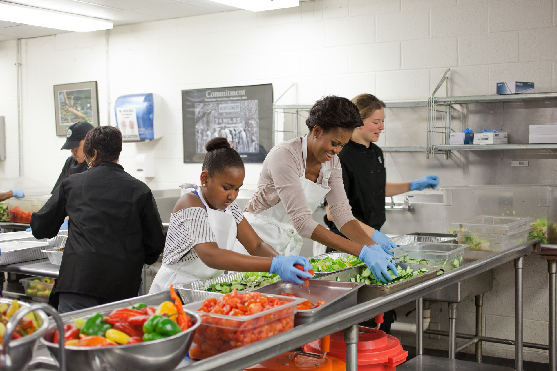 First Lady Michelle Obama and daughter Sasha Obama participate in a service event  at DC Central Kitchen