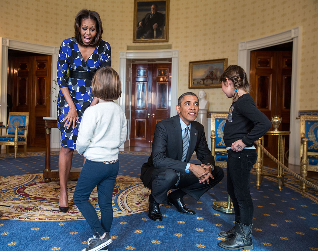 President Barack Obama and First Lady Michelle Obama greet visitors in the Blue Room during a White House tour.