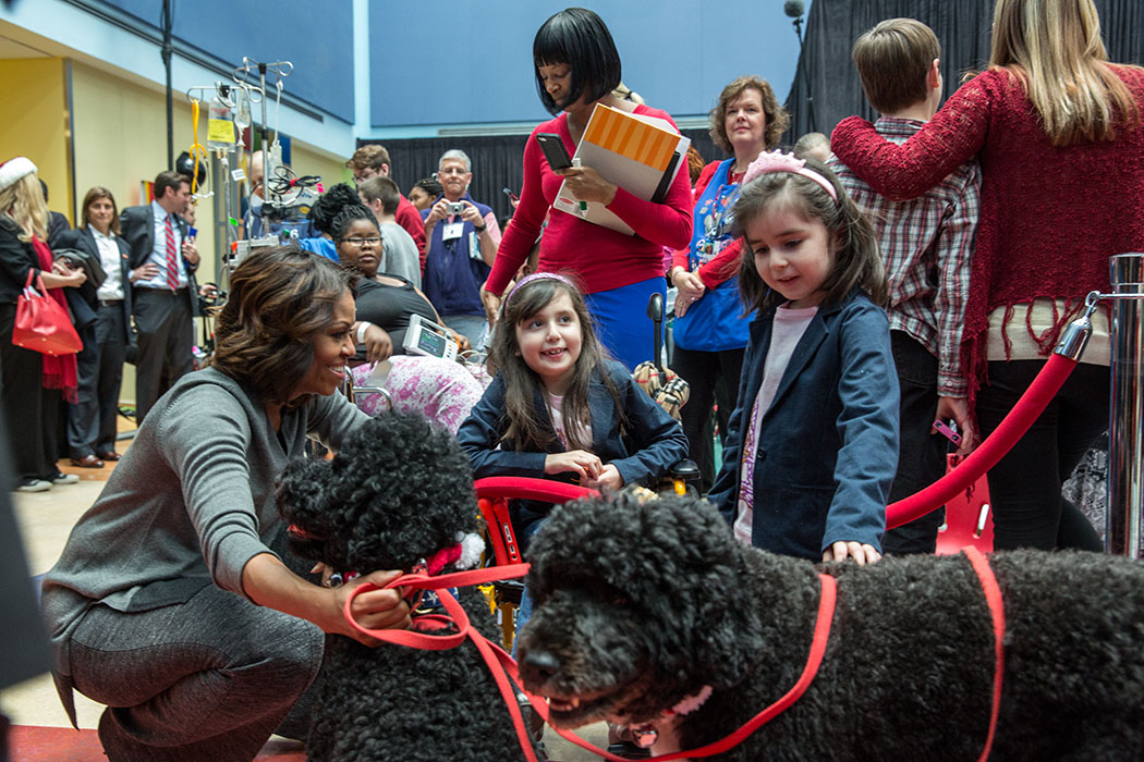 First Lady Michelle Obama, with Obama family pets, Bo and Sunny, greets children during a Christmas holiday program at the Children’s National Medical Center in Washington, D.C., Dec. 16, 2013. (Official White House Photo by Amanda Lucidon)