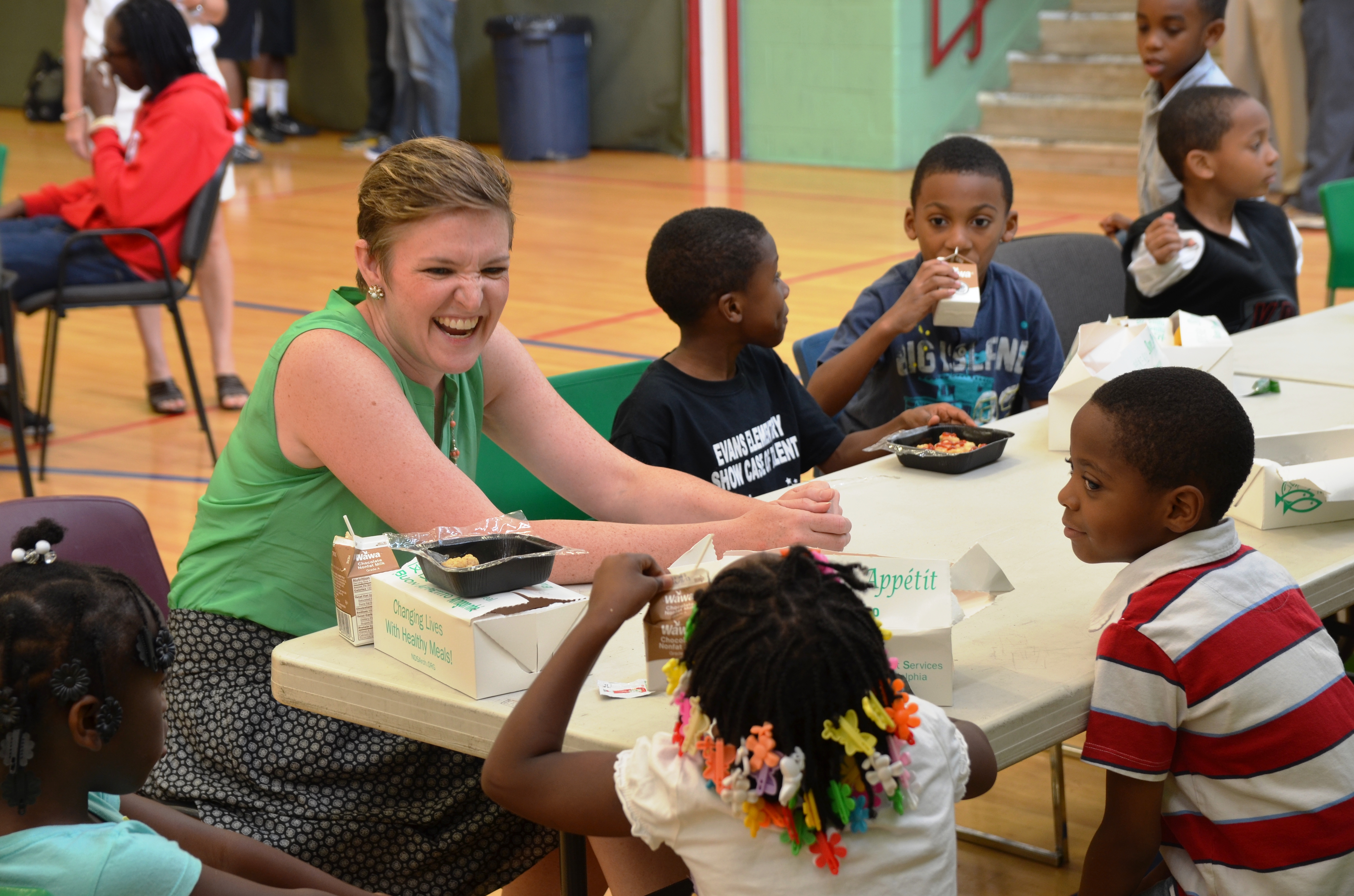 The Director of USDA’s Center for Faith-Based and Neighborhood Partnerships, Norah Deluhery, eats lunch with kids