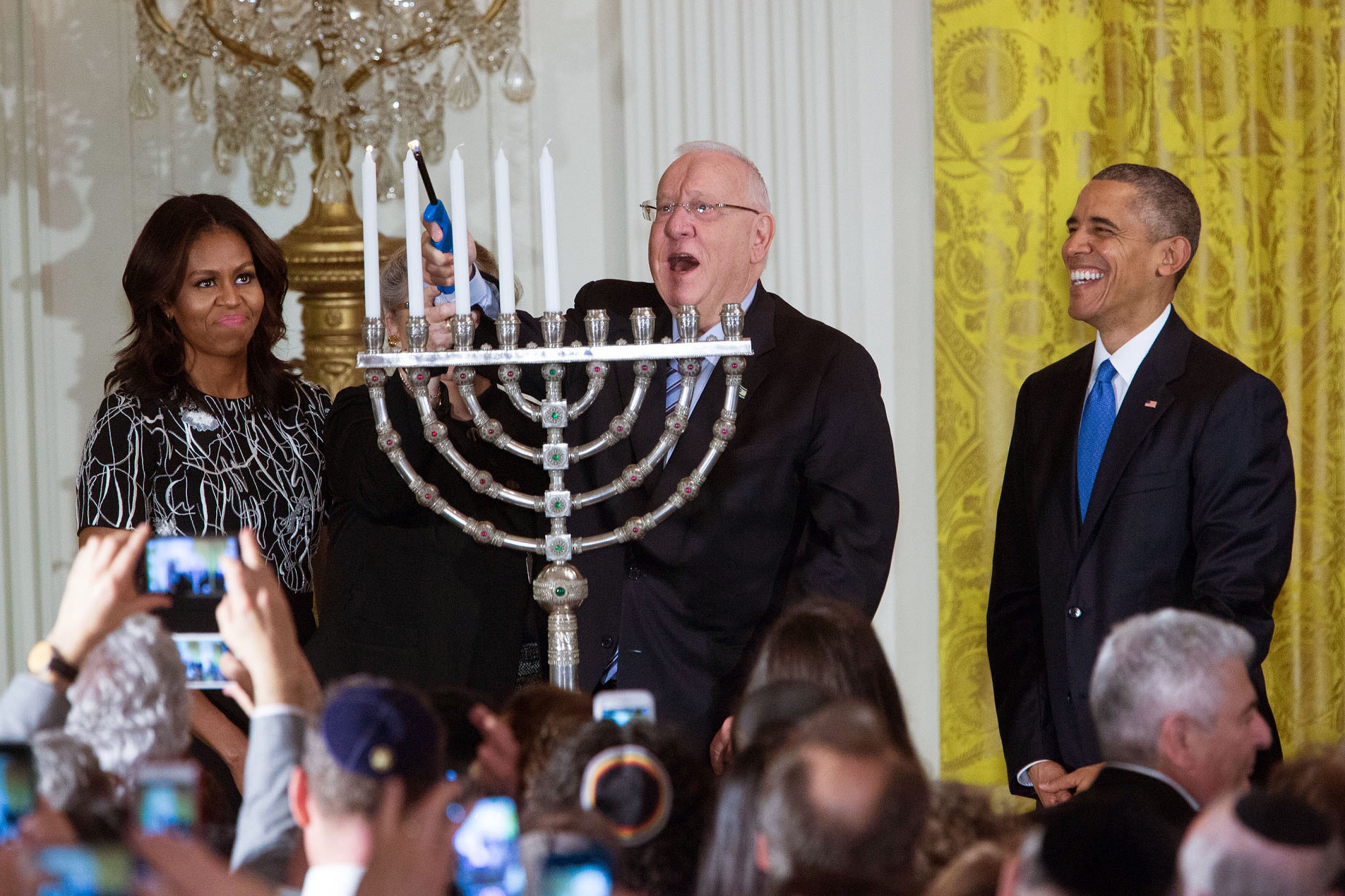 President Barack Obama and First Lady Michelle Obama watch as President Reuven Rivlin of Israel and Mrs. Nechama Rivlin light the menorah during Hanukkah reception #1 in the East Room of the White House, Dec. 9, 2015. (Official White House Photo by Amanda Lucidon)