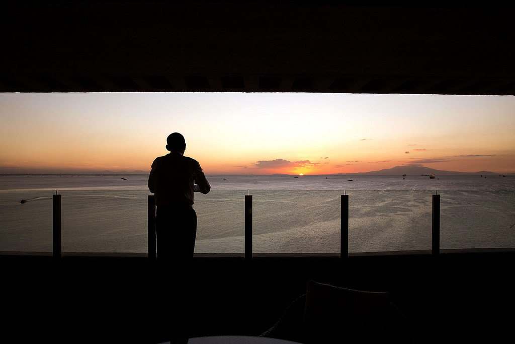 The President watches the sun set over Manila Bay from his hotel balcony in Manila." (Official White House Photo by Pete Souza)