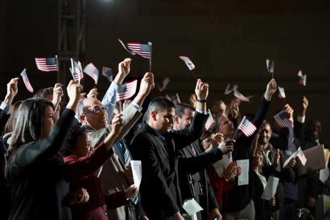 Newly naturalized citizens wave American flags after taking the Oath of Allegiance during a naturalization ceremony keynoted by the President at the National Archives in Washington, D.C., Dec. 15, 2015. (Official White House Photo by Pete Souza)