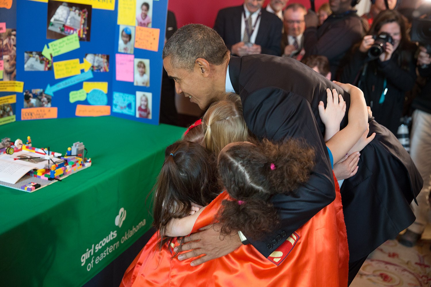 President Barack Obama hugs Emily Bergenroth, Alicia Cutter, Karissa Cheng, Addy O’Neal, and Emery Dodson, all six-year-old Girl Scouts, from Tulsa, Oklahoma after viewing their science exhibit during the 2015 White House Science Fair celebrating student winners of a broad range of science, technology, engineering, and math (STEM) competitions, in the Red Room, March 23, 2015. The girls used Lego pieces and designed a battery-powered page turner to help people who are paralyzed or have arthritis. (Official White House Photo by Pete Souza)